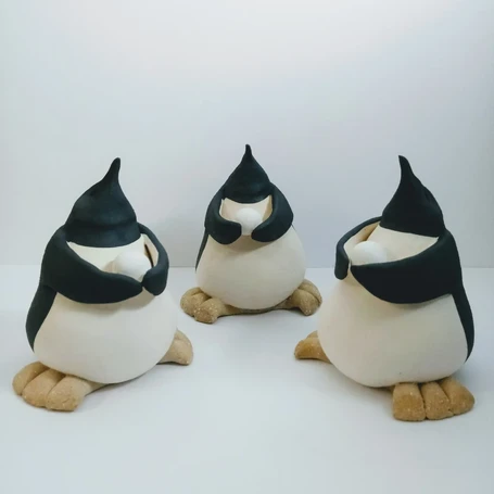 small ceramic penguins holding snowballs